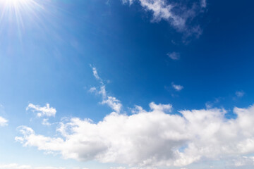 Naklejka na ściany i meble blue sky background. white fluffy clouds above horizon. sunny summer weather at high noon