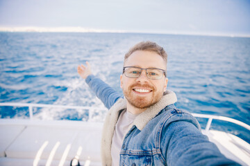 Fototapeta premium Portrait smile happy man driver captain of white luxury yacht holding helm wheel, summer travel on boat sea