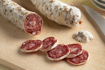 Traditional French sausage with duck meat and slices on a cutting board close up