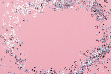 Holiday Festive background. gold and silver star confetti glitter scattered on pink background....
