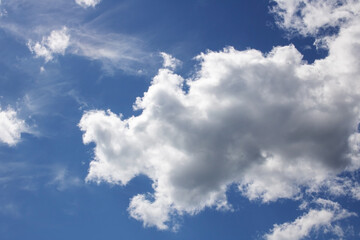 Naklejka na ściany i meble Clouds in a bright blue sky in sunlight