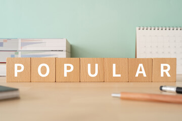 人気のイメージ｜「POPULAR」と書かれた積み木が置かれたデスク