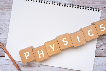 物理学のイメージ｜「PHYSICS」と書かれた積み木、ノート、ペン