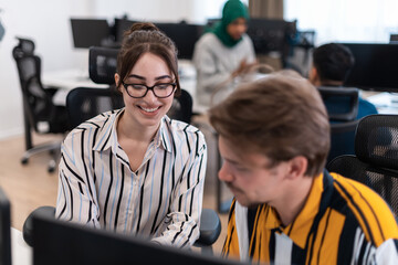 Business couple working together on project using tablet and desktop computer at modern open plan startup office. Selective focus 