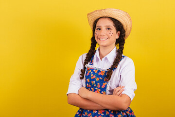 Girl wearing typical clothes for Festa Junina. Arms crossed, smiling and happy. For the Festival do...