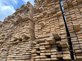 Wooden boards, lumber, industrial wood, timber. Pine wood timber stack of natural rough wooden boards on building site. Industrial timber building materials