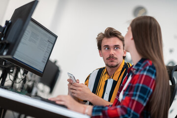Business couple working together on project using tablet and desktop computer at modern open plan startup office. Selective focus 