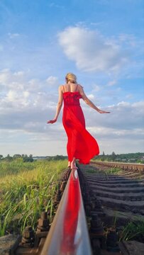 Girl in a red dress on the railroad