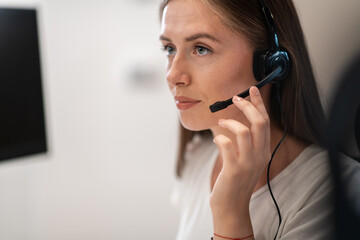 Helpline female operator with headphones in call centre.Business woman with headsets working in a call center. Selective focus 