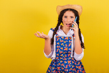Girl wearing typical clothes for Festa Junina. on mobile voice call, connected, call. For the...