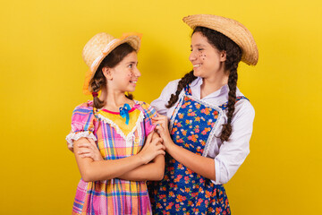 sisters and friends, wearing typical clothes of the Festa Junina. Hugging, smiling. united,...