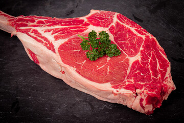 raw Tomahawk steak on slate background