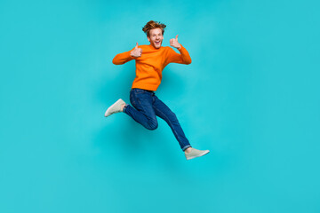 Fototapeta na wymiar Full length photo of funky cool man wear orange pullover jumping high thumb up isolated teal color background