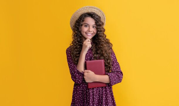 smiling kid with frizz hair read book on yellow background