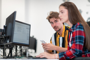 Business couple working together on project using tablet and desktop computer at modern open plan startup office. Selective focus 