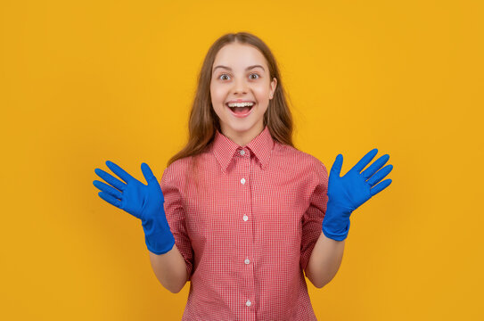 amazed child in rubber gloves on yellow background