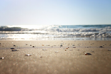 Sea waves and warm sunset light, calm and relaxing sandy beach