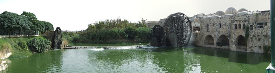 Hama, Syria. 13-10-2010. Panorama photo. The waterwheels or norias of Hama. Before the war. - obrazy, fototapety, plakaty