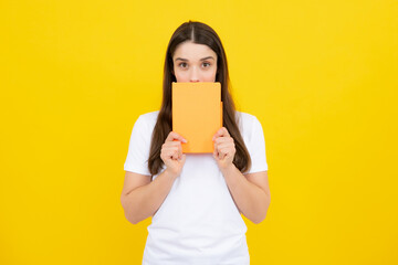 Charming student isolated on yellow color background. Woman high school student hold notebooks....