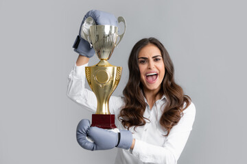 Woman in boxing gloves hold champion winner cup, trophy. Screaming strong young woman boxer. Strong aggressive business woman concept. Winner female boxer Isolated on gray background. - Powered by Adobe