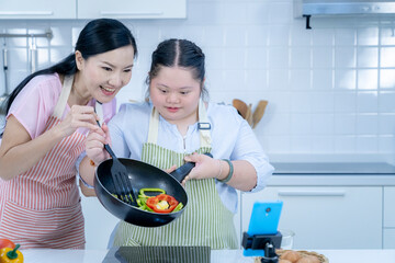 Asian person with Down syndrome cooking with mom. Brain growth learning family love intelligence...