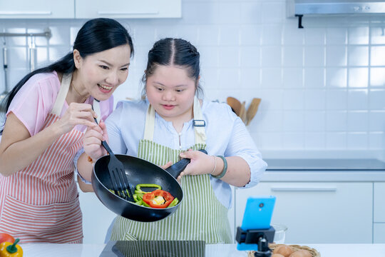 Asian Person With Down Syndrome Cooking With Mom. Brain Growth Learning Family Love Intelligence Cooking