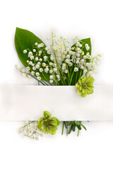 Bouquet with white flowers Lily of the valley ( Convallaria majalis, May bells, may-lily ), hellebores and white paper card with space for text on white background. Top view, flat lay