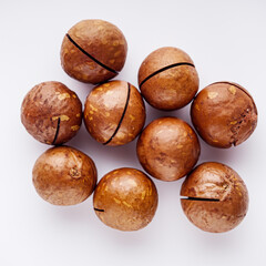 fresh macadamia nuts on a white acrylic background