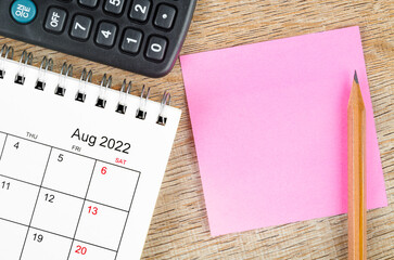 Blank sticky note on August 2022 desk calendar on wooden background for your text.
