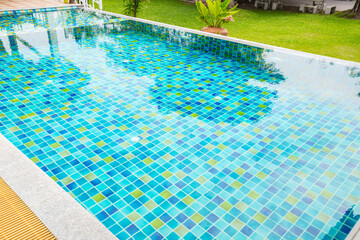 Macro from Swimming pool with clear blue water in a garden area, surrounded by plants