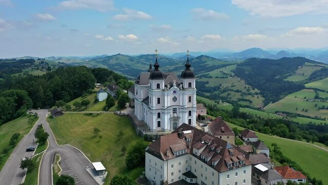 Aerial drone shot of Basilica Sonntagberg in Austria. Drone view of a mountain landscape in Austria with a church. Overview among fields and Alpine mountains