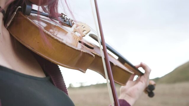Video of young woman playing violin in a landscape. Concept of musicians and hobbies.