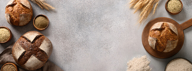 Banner of homemade freshly baked whole grain and hemp bread on gray background. View from above....