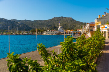 Obraz premium BOZBURUN, MUGLA, TURKEY: Landscape with a view of the village, ships and boats at the boardwalk in Bozburun