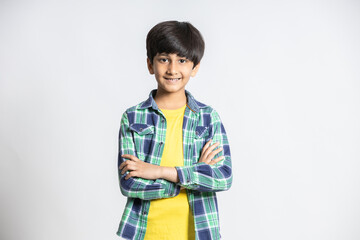 Portrait of smiling cute little indian boy standing with cross arms isolated on white studio background. - Powered by Adobe