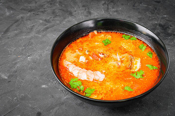 delicious hot traditional tom yam soup on a black background