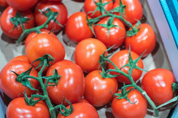 Close up focus on fresh ripe tomato vegetables in the box at grocery food store.Buy natural healthy food ingredients for healthy eating and good taste.red tomatoes on food aisle in the mall