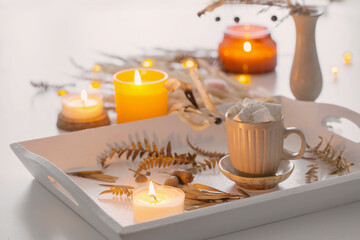 two cups of  coffee  with marshmallows  and autumn decor on white wooden tray