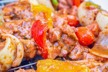 Barbecue skewers meat with vegetables on grill close up