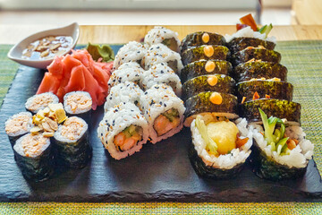 Sliced rolls of salmon sushi with ginger, wasabi and honey sauce