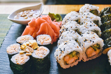 Sliced rolls of salmon sushi with ginger, wasabi and honey sauce