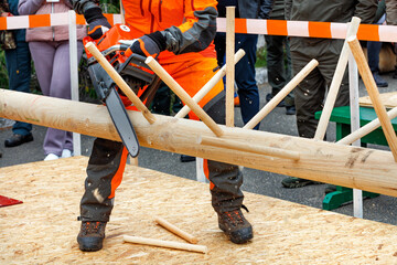 A worker deftly demonstrates his skill with a chainsaw at a lumberjack competition.