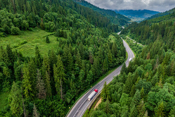convoys with cargo. trucks on the higthway. cargo delivery driving on asphalt road through the mountains. seen from the air. Aerial view landscape. drone photography.