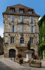 Fototapeta na wymiar historic Bourgeoisie building and statue in the fortified town center of Beaulieu-sur-Dordogne