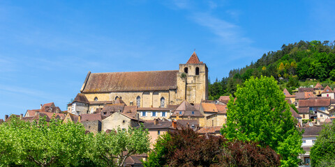 Fototapeta na wymiar view of the historic village center of Saint-Cyprien with traditional brown stone houses and catholic church