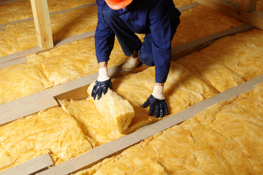 Construction worker thermally insulating house