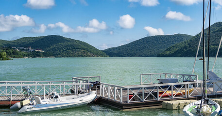 Naklejka premium Empty pier for boats at blue lake water background at sunny summer day
