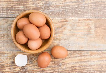 Chicken eggs in a wooden bowl Farm fresh organic eggs laid on a rustic wood