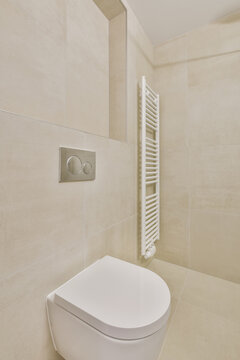 Interior of restroom with heated towel rails and toilet bowl