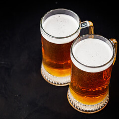 mug of beer and a set of dry fish snacks on a dark background